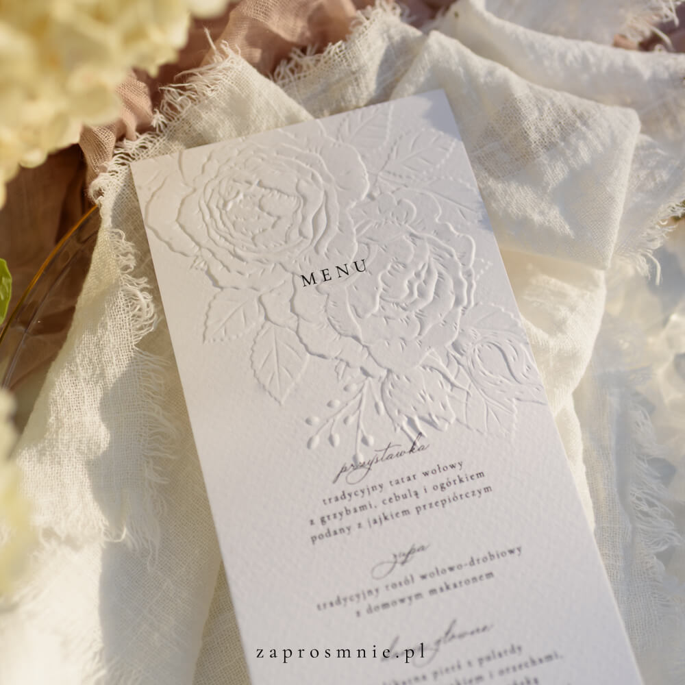 Zestaw białego menu weselnego z eleganckim tłoczeniem kwiatowym oraz winietki z pieczęcią z lakiem, luksusowa i spójna papeteria ślubna, która dodaje romantycznego i eleganckiego charakteru stołowi weselnemu, praktyczny element ułatwiający organizację miejsc i informujący o serwowanych potrawach, idealny do klasycznych i glamour aranżacji, menu z tłoczeniem kwiatowym
