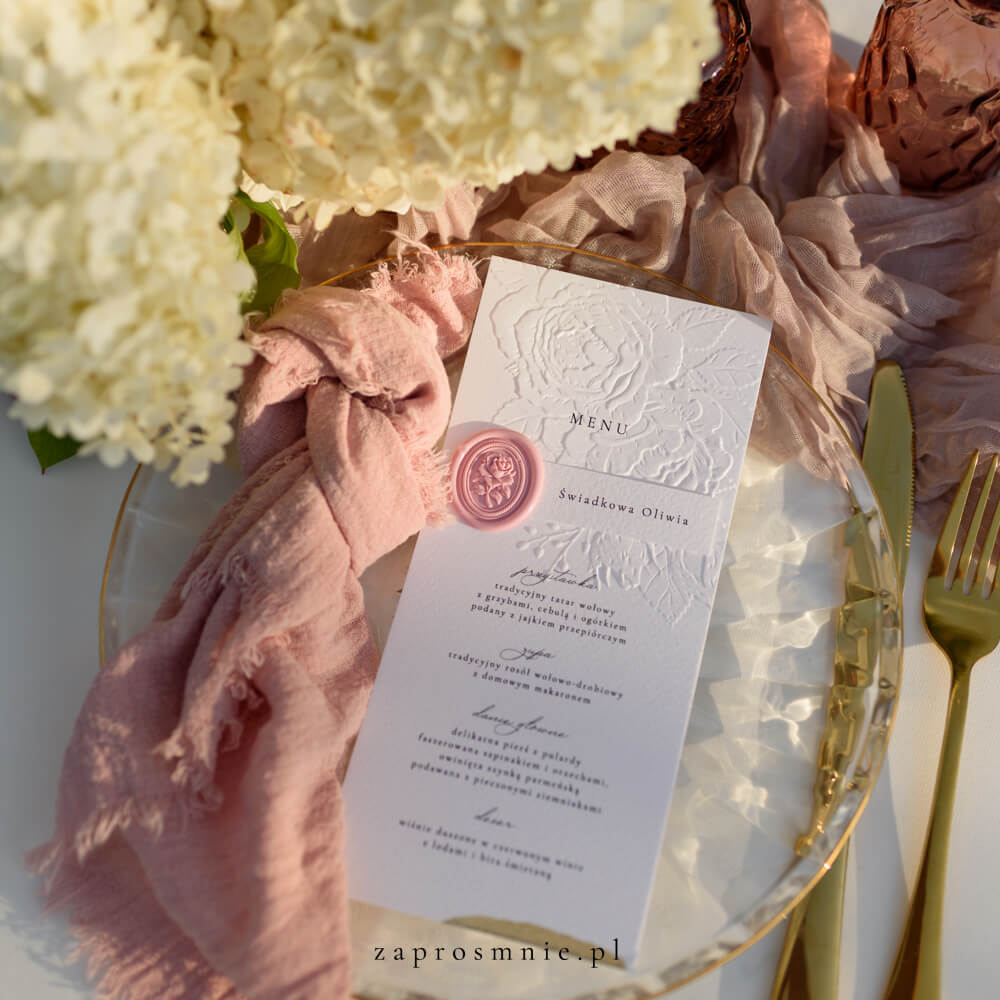 Zestaw białego menu weselnego z eleganckim tłoczeniem kwiatowym oraz winietki z pieczęcią z lakiem, luksusowa i spójna papeteria ślubna, która dodaje romantycznego i eleganckiego charakteru stołowi weselnemu, praktyczny element ułatwiający organizację miejsc i informujący o serwowanych potrawach, idealny do klasycznych i glamour aranżacji, menu z tłoczeniem kwiatowym